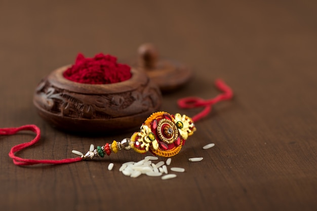 인도 축제 : 우아한 Rakhi, Rice Grains 및 Kumkum이있는 Raksha Bandhan 배경