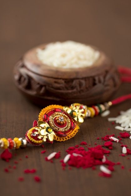 인도 축제 : 우아한 Rakhi, Rice Grains 및 Kumkum이있는 Raksha Bandhan 배경