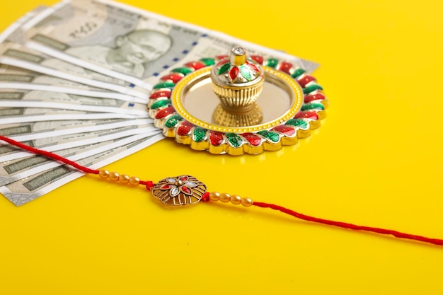 Festival indiano raksha bandhan un tradizionale braccialetto indiano con kumkumrise e valuta indiana