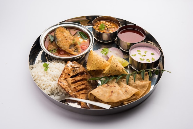 Indian Fish Platter or thali - Popular sea food, Non vegetarian meal from Mumbai, Konkan, Maharashtra, Goa, Bengal, Kerala served in a steel plate or over banana leaf