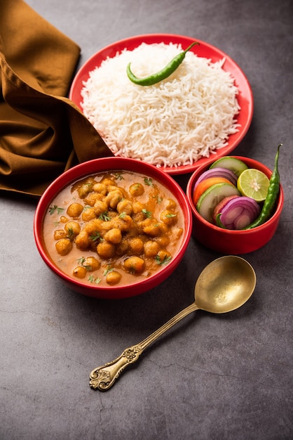 Indian food chole chawal or spicy Chickpea curry with plain rice served with green salad