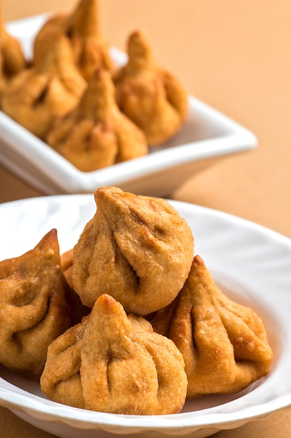 Photo indian food: modak, maharashtra sweet dish, favourite sweet of lord ganesha, greeting card design.