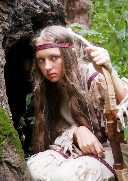 Photo indian girl with a bow in his hands in ambush