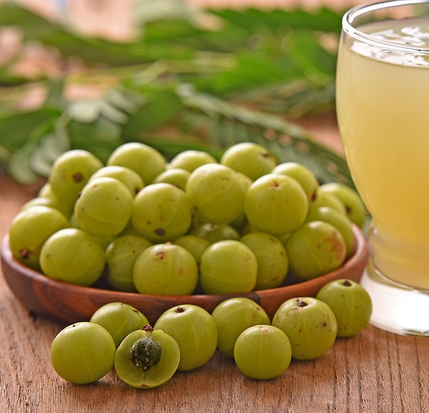 Indian gooseberry  in wooden bowl on a wooden floor.