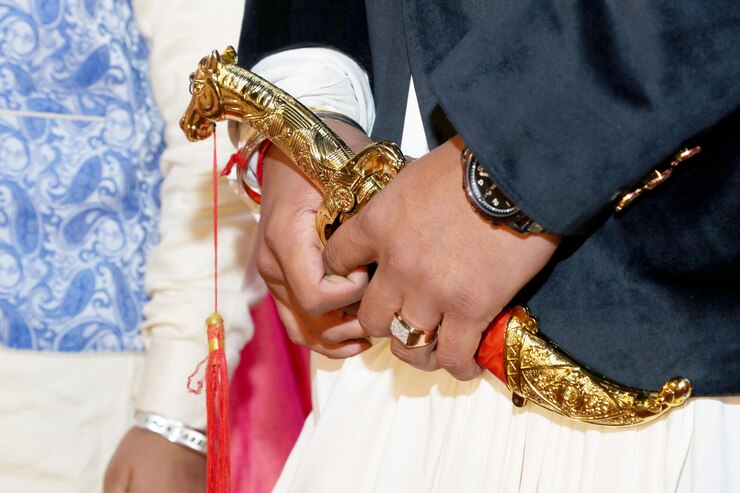 インドの新郎は結婚式で伝統的なナイフを保持します