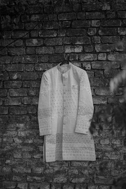 Indian grooms wedding sherwani hanging on frame