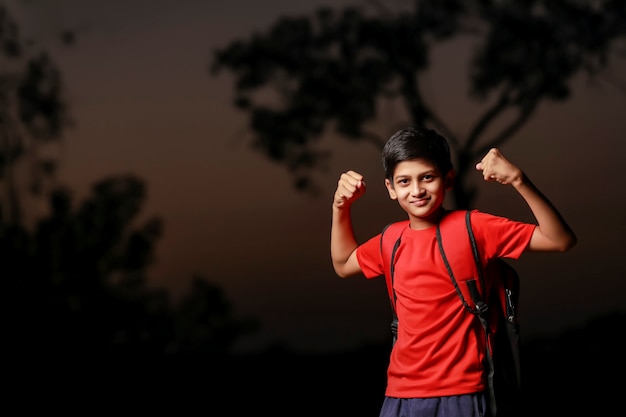 Indian happy and excited child doing winner gesture with arms raised