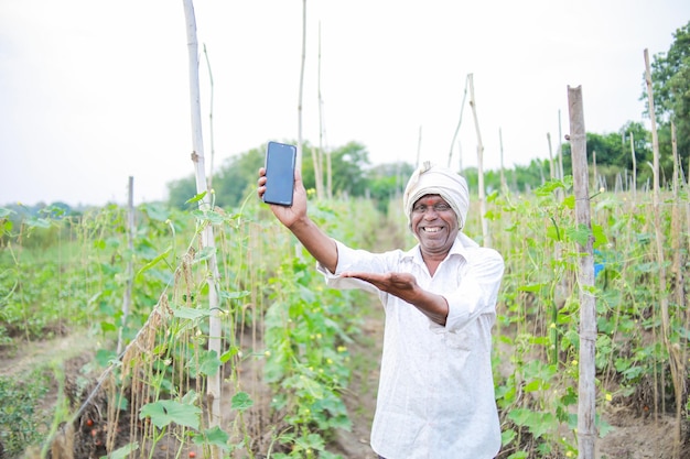 Indian happy farmer holding mobile in hand