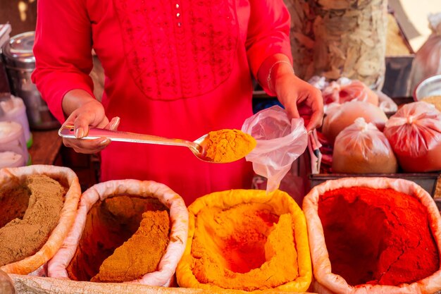 Indian happy woman salling spices in bazaar in Goa