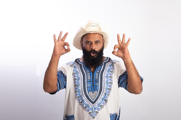 Indian Healthy middle aged man wearing cowboy cap Standing amp Showing okay gesture with both hands