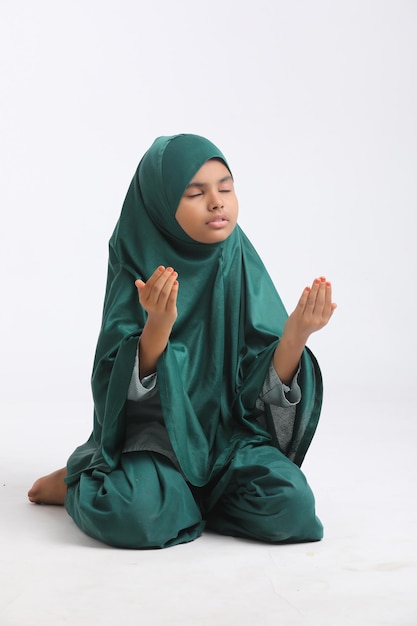 Indian islamic religious girl praying on white background