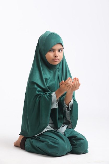 Indian islamic religious girl praying on white background