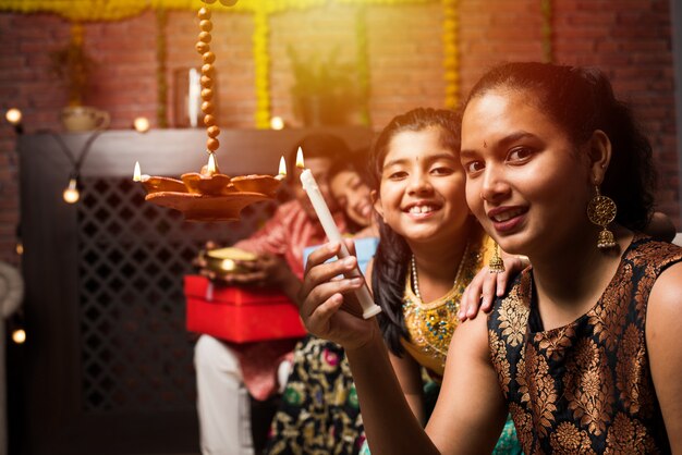 Bambini indiani che celebrano diwali, deepawali, bhai dooj o rakhi o raksha bandhan con rangoli di fiori, regali, diya