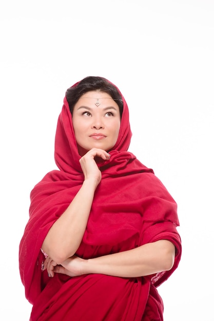 Indian lady dressed in traditional red-coloured sari is thinking about her students and being very demanding teacher she knows how to succeed with them.