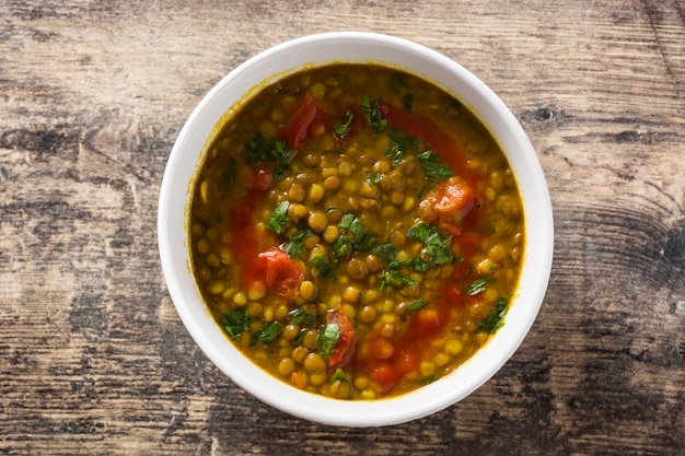 나무 테이블에 그릇에 인도 렌즈 콩 수프 dal (dhal). 티