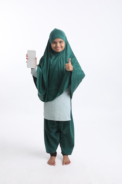 Indian little girl showing smartphone on white background