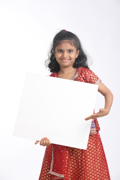 복사 공간이 있는 화이트 보드를 보여주는 인도 어린 소녀