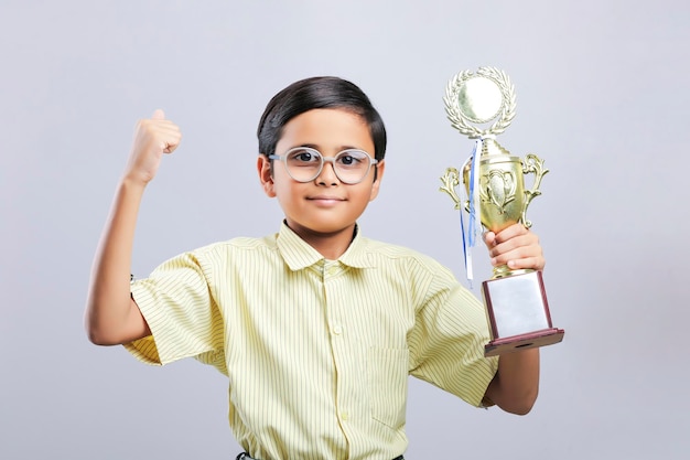 Indian little school boy giving expression with trophy