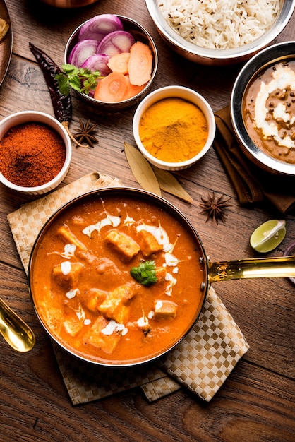 Indian Lunch or Dinner main course food in group includes Paneer Butter Masala, Dal Makhani, Palak Paneer, Roti, Rice etc, Selective focus