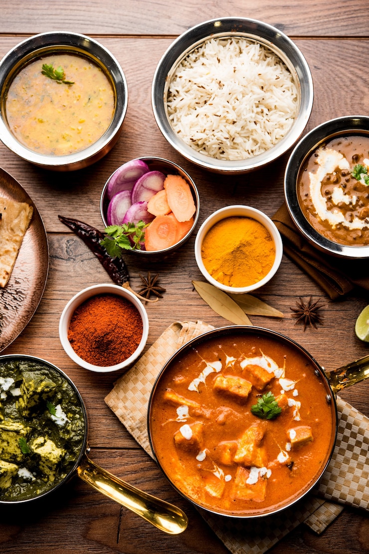 Photo indian lunch or dinner main course food in group includes paneer butter masala, dal makhani, palak paneer, roti, rice etc, selective focus