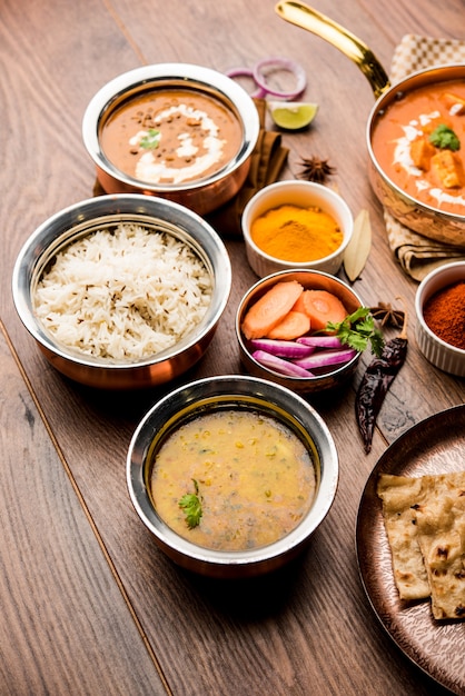 Indian Lunch or Dinner main course food in group includes Paneer Butter Masala, Dal Makhani, Palak Paneer, Roti, Rice etc, Selective focus