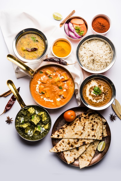 Indian Lunch or Dinner main course food in group includes Paneer Butter Masala, Dal Makhani, Palak Paneer, Roti, Rice etc, Selective focus