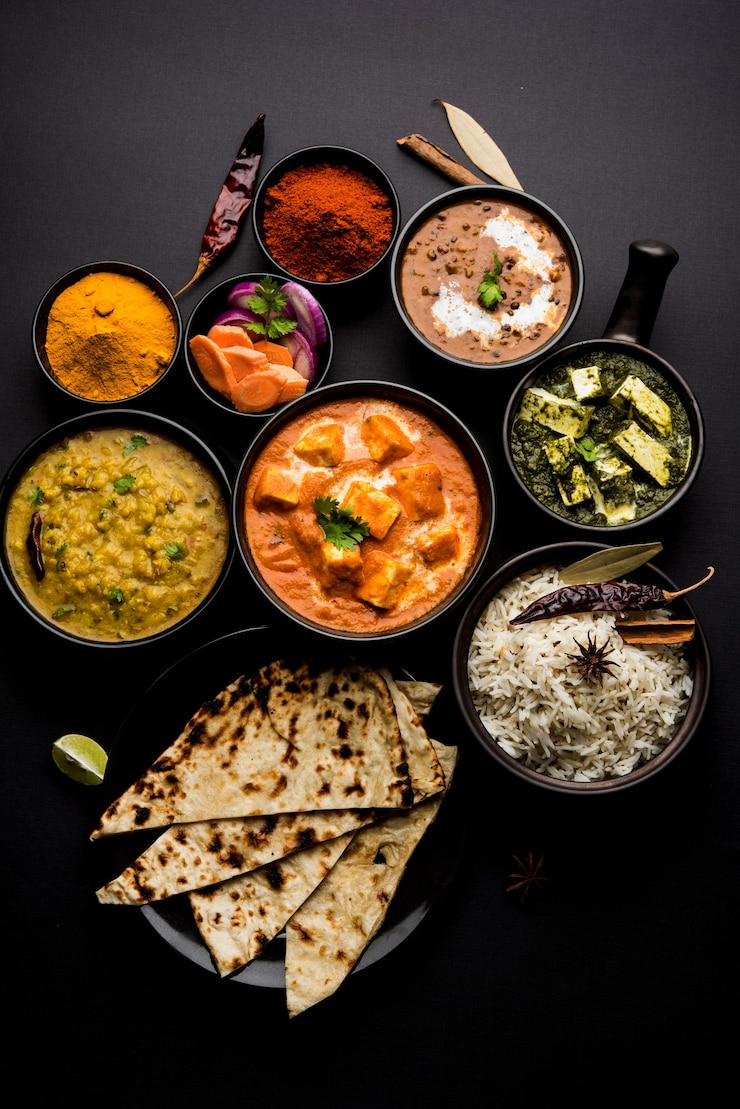 Photo indian lunch or dinner main course food in group includes paneer butter masala, dal makhani, palak paneer, roti, rice etc, selective focus