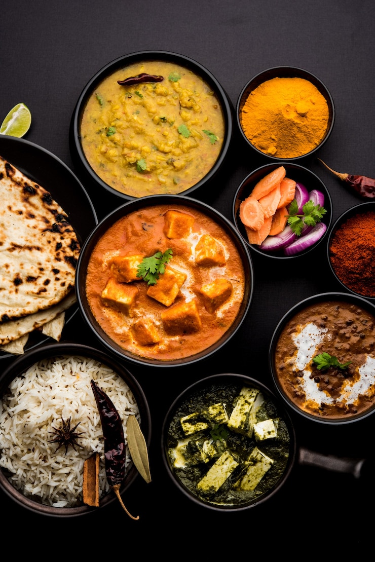 Photo indian lunch or dinner main course food in group includes paneer butter masala, dal makhani, palak paneer, roti, rice etc, selective focus