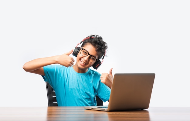 Indian male syudent or kid studying online using laptop. Asian child attending online school using computer