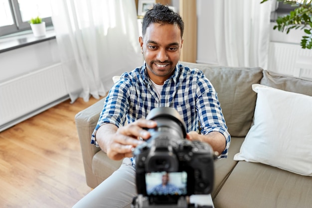 indian male video blogger adjusting camera at home