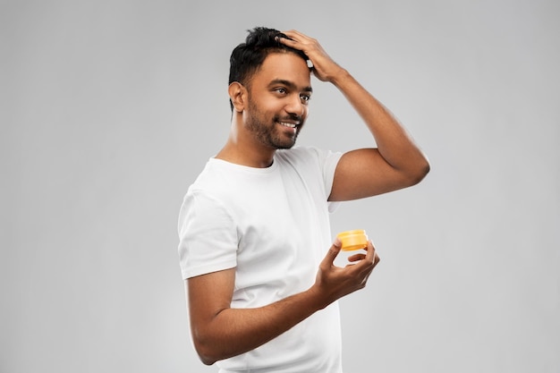 indian man applying hair wax or styling gel