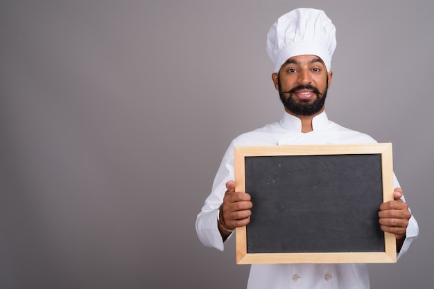 Indian man chef holding empty black board with copy space