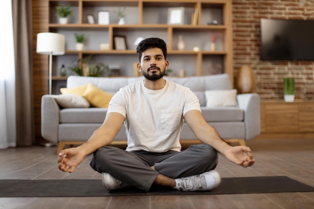 Foto uomo indiano che fa esercizio di meditazione a casa