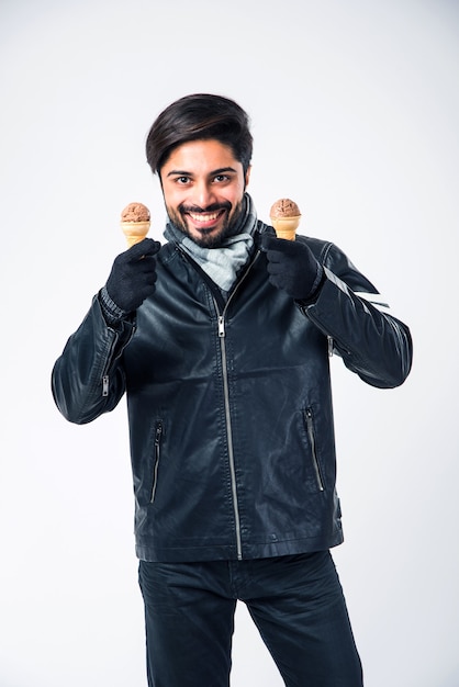 Indian man eating Ice Cream in warm clothes on white background