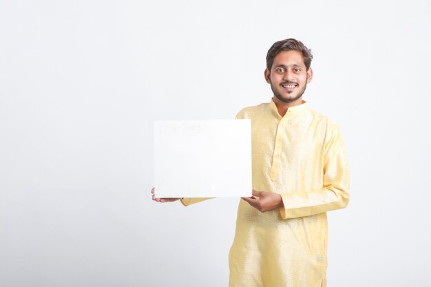 Indian man holding white board standing over white wall