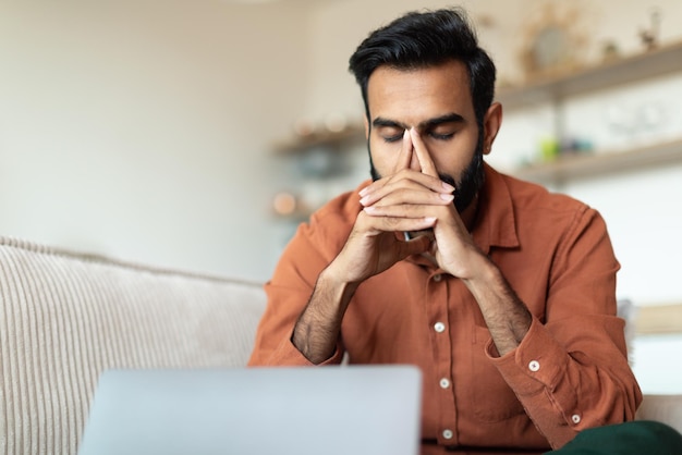 Indian man at laptop experiencing issues working online from home