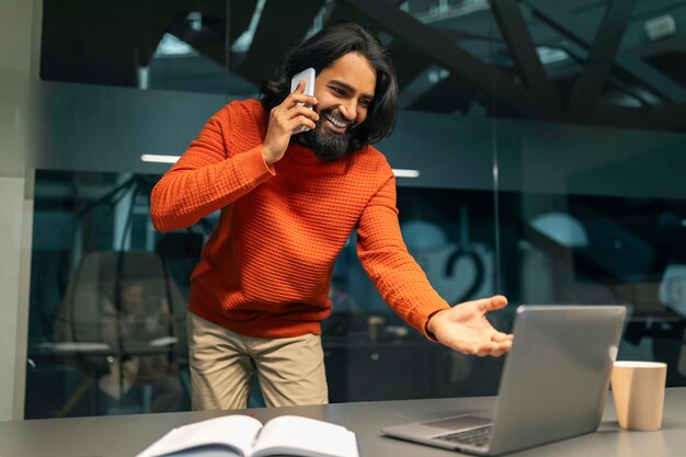 Indian man manager multitasking at modern dark office