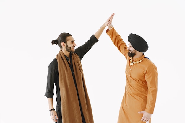 Indian man and Pakistani man on white background. Giving high five in agreement. Friendship between nations.
