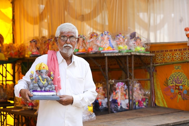 Indian man selling ganesha sculpture