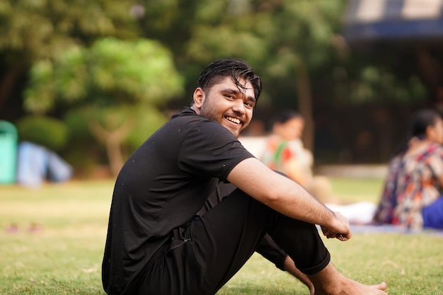 Indian man sitting in the grass and smiling