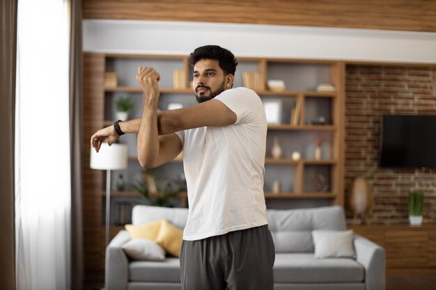 Photo indian man stretching arms for muscle warm up