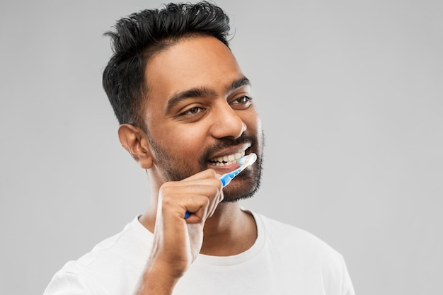 indian man with toothbrush cleaning teeth