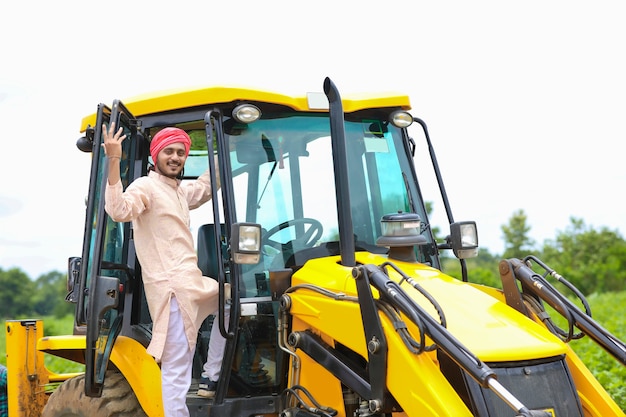 Indian man working with heavy equipment vehicle at construction site.