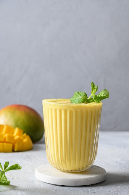 Indian mango or turmeric lassi on gray background