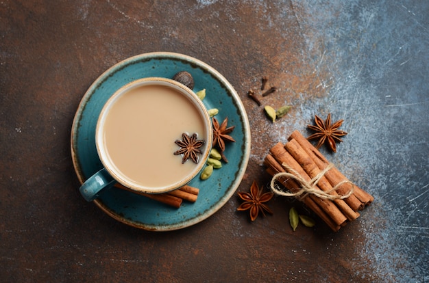 Indian masala chai tea. Spiced tea with milk on dark rusty Top view, flat lay.