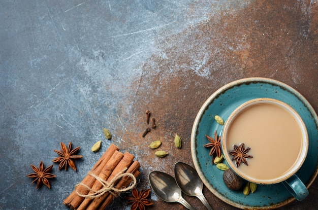 Indian masala chai tea. Spiced tea with milk on dark rusty 