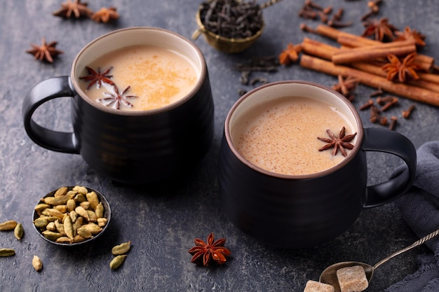 Indian masala tea with milk and spices in mug Grey background Close up