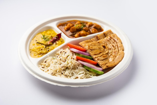 Photo indian mini meal parcel platter combo thali with chole masala roti dal tarka jeera rice salad