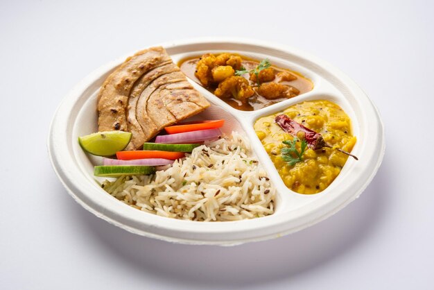 Indian mini meal parcel platter or combo thali with Gobi Masala roti dal tarka jeera rice salad