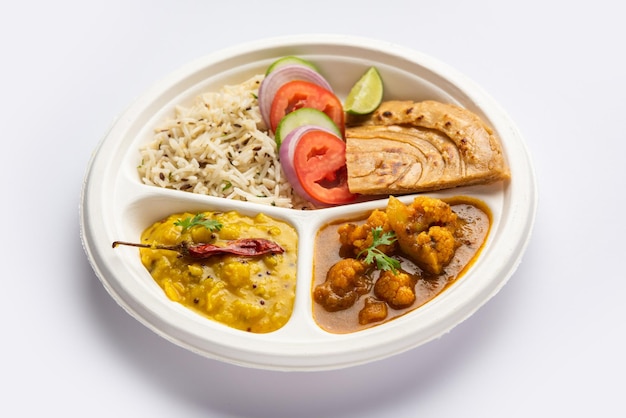 Indian mini meal parcel platter or combo thali with Gobi Masala roti dal tarka jeera rice salad